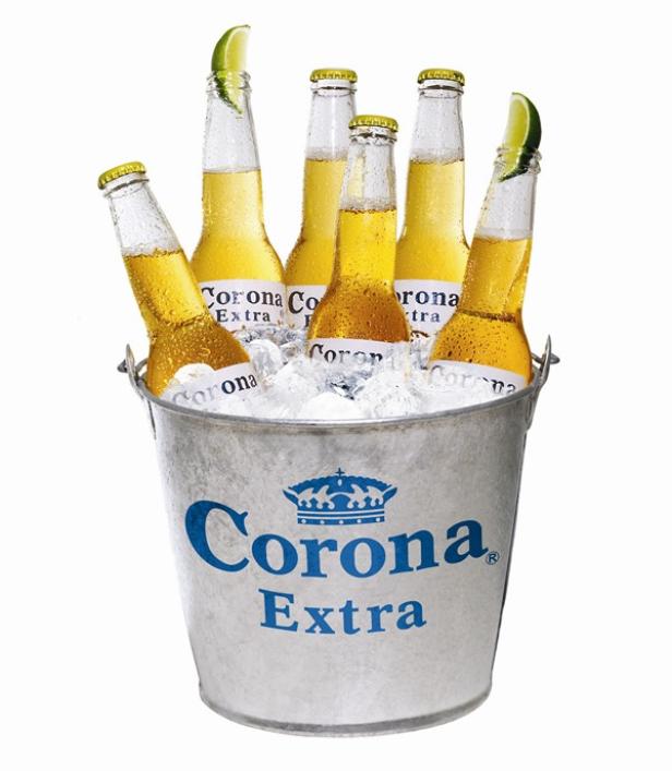 Ein Eimer mit Eis und sechs Flaschen Corona Extra, einige mit Limetten garniert.