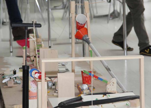 Eine komplexe Kettenreaktion-Maschine aus Holz, Bechern und anderen Gegenständen.