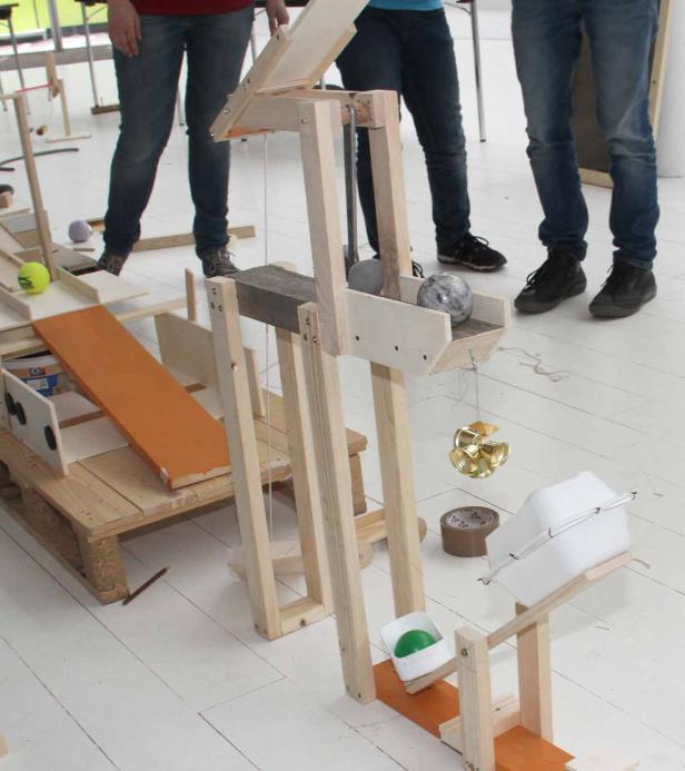 Eine selbstgebaute Murmelbahn aus Holz mit verschiedenen Elementen und Hindernissen.