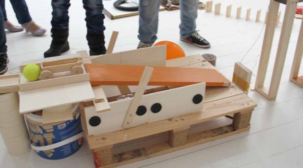 Eine selbstgebaute Murmelbahn aus Holz mit verschiedenen Elementen und Hindernissen.