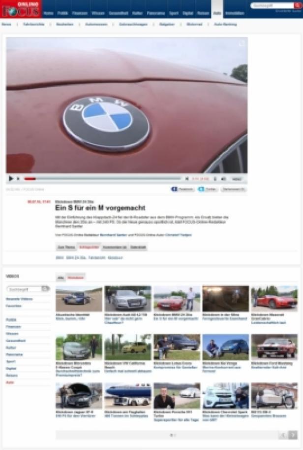 Das BMW-Logo auf der Motorhaube eines roten Autos.