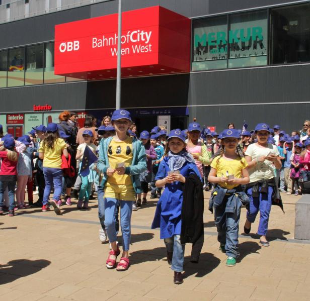 Eine Gruppe von Kindern mit EU-Mützen vor dem BahnhofCity Wien West.