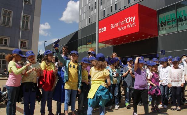 Eine Gruppe von Kindern mit EU-Flaggen vor dem BahnhofCity Wien West.