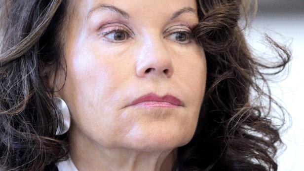 Das Porträt einer Frau mit braunen Haaren und einem silbernen Ohrring.