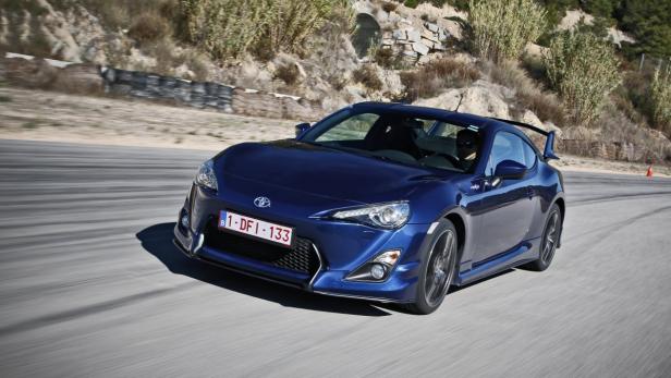 Ein blauer Toyota GT86 fährt auf einer kurvenreichen Straße.
