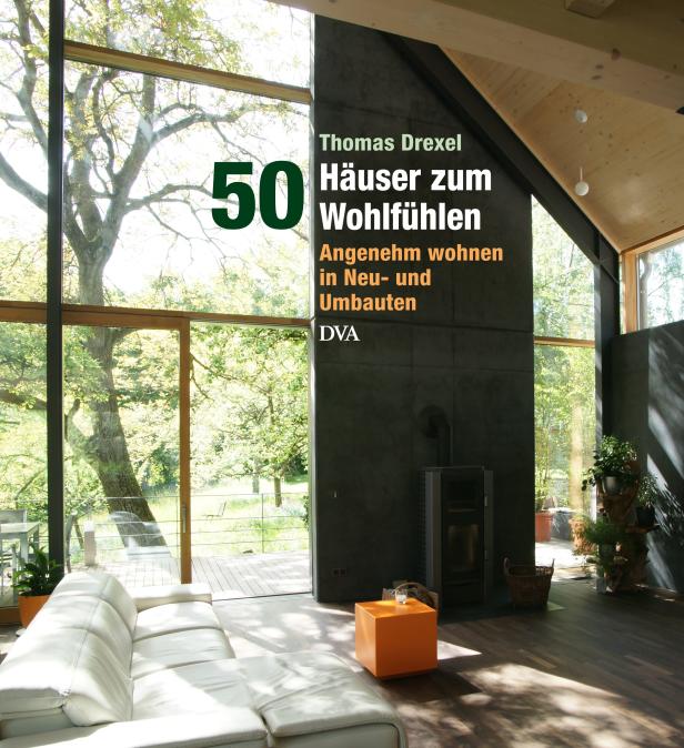 Ein modernes Wohnzimmer mit großen Fenstern und Blick ins Grüne.