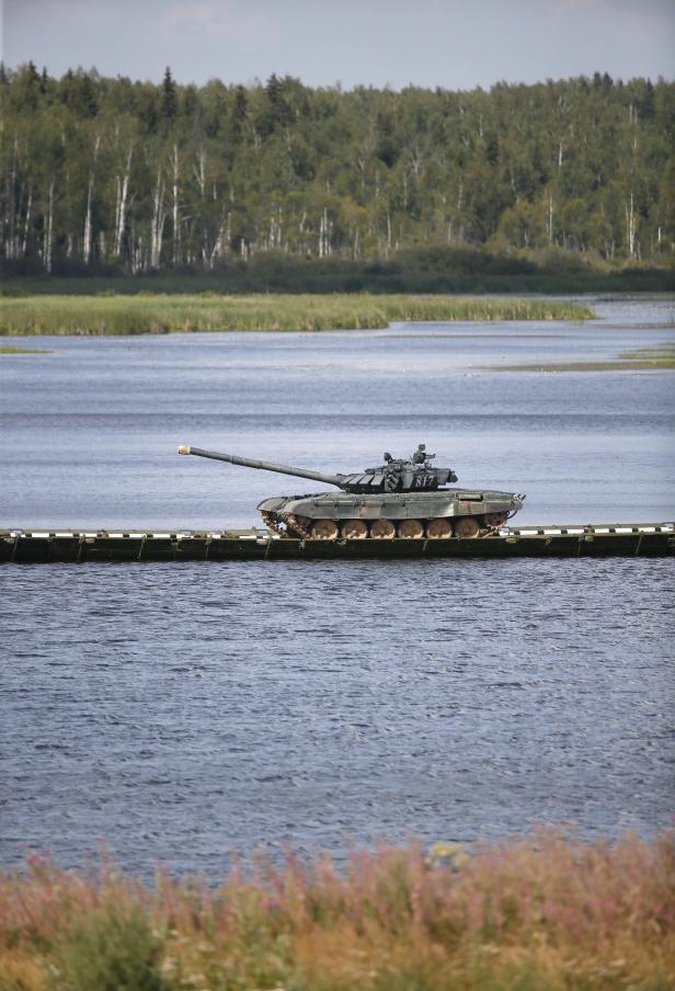 Ein Panzer überquert einen Fluss auf einer Pontonbrücke.