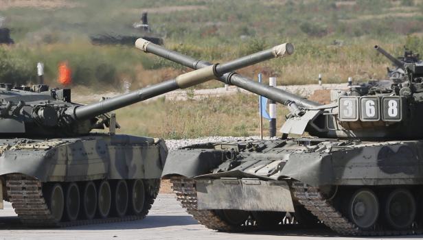Zwei russische Panzer stehen mit gekreuzten Rohren auf einem Übungsgelände.
