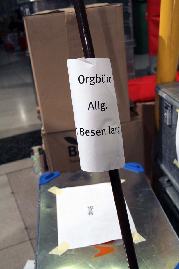 Ein Besen mit einem Zettel, der mit „Orgbüro Allg. 1 Besen lang“ beschriftet ist.