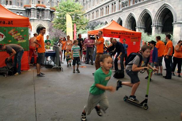 Kinder nehmen an einer Veranstaltung im Freien mit Ständen und Spielen teil.