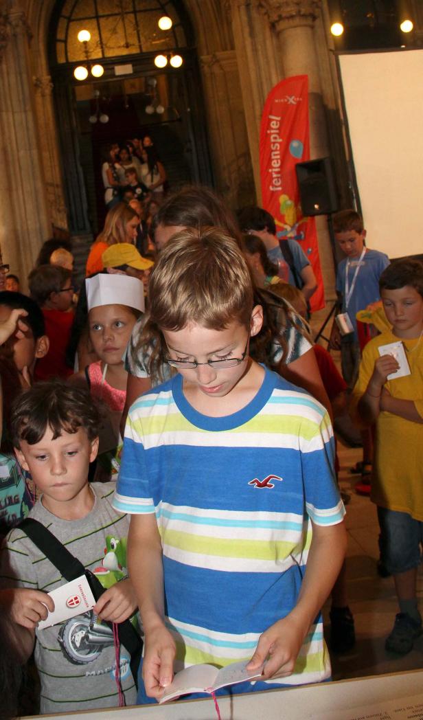 Eine Gruppe von Kindern steht in einem Raum und liest in Büchern.