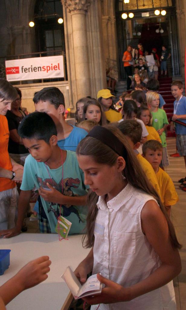 Eine Gruppe Kinder steht an einem Tisch beim „Ferienspiel“.