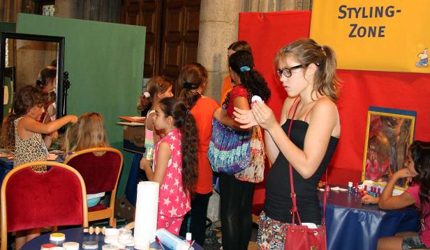 Mehrere Mädchen in einer „Styling-Zone“ bei einer Veranstaltung.