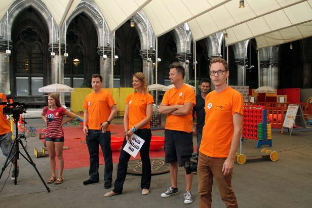 Eine Gruppe von Personen steht vor einem Gebäude mit gotischer Architektur.