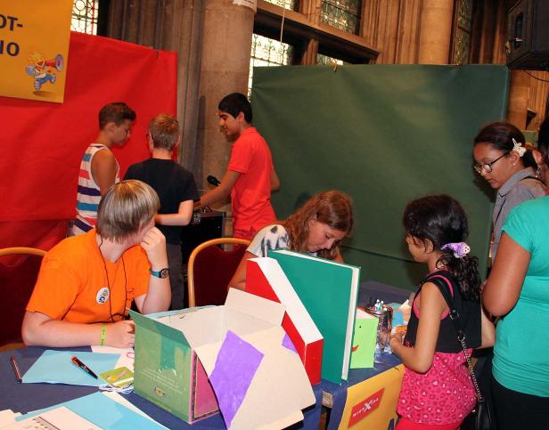 Eine Gruppe von Kindern steht an einem Stand und bastelt oder spielt.