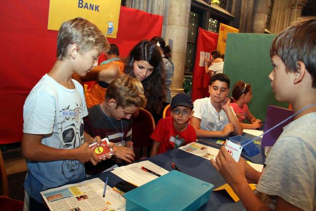Eine Gruppe Kinder nimmt an einem Lernspiel zum Thema Finanzen teil.