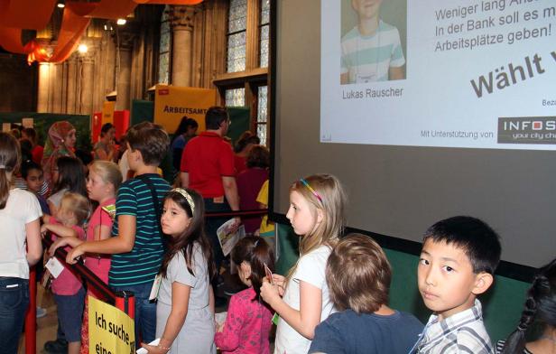 Eine Gruppe von Kindern steht an einem Stand des Arbeitsamtes.