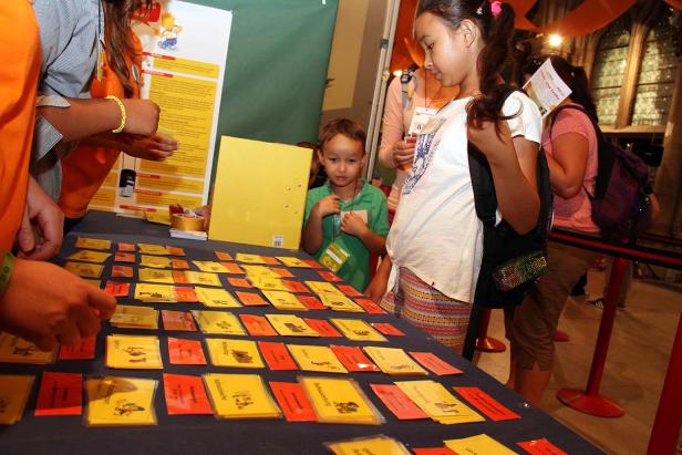 Kinder betrachten und sortieren Karten auf einem Tisch.