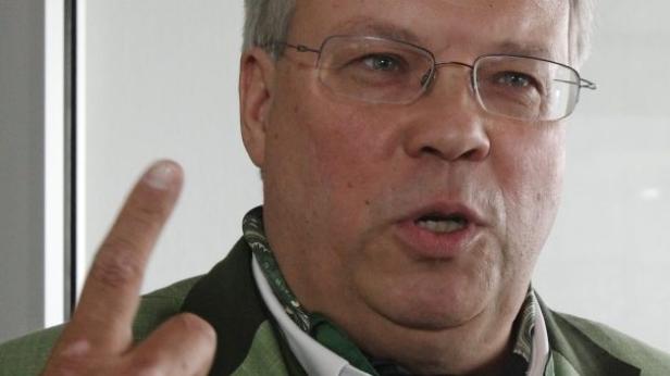 Ein Mann mit Brille gestikuliert und spricht.