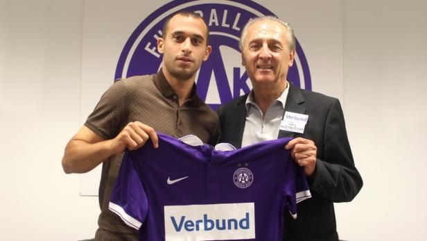 Zwei Männer halten ein lila Trikot des Fussballklubs Austria Wien.