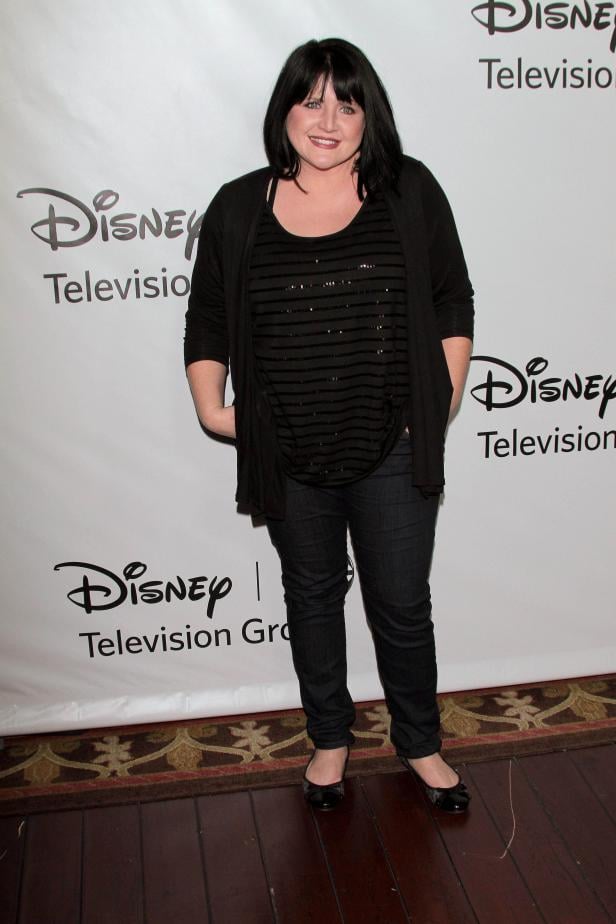Eine Frau posiert vor einem Disney Television Hintergrund.