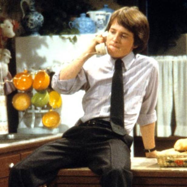 Michael J. Fox sitzt auf einer Küchentheke und telefoniert.