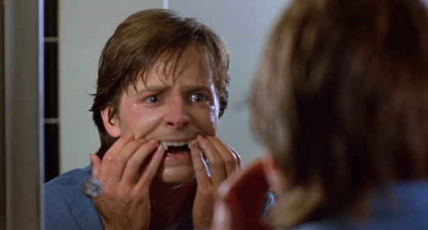 Michael J. Fox als Teenager-Wolf mit Vampirzähnen vor einem Spiegel.