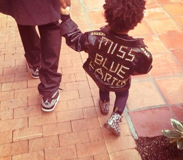 Ein Kind mit einer Jacke mit der Aufschrift „Miss Blue Carter“ geht an der Hand eines Erwachsenen.