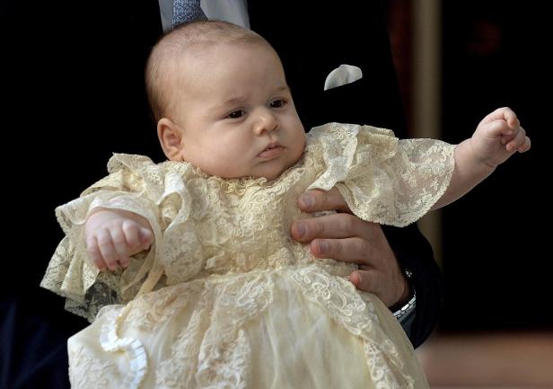 Prinz George wird in einem cremefarbenen Taufkleid gehalten.