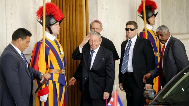 Raúl Castro grüßt vor Schweizergardisten und Sicherheitsbeamten.