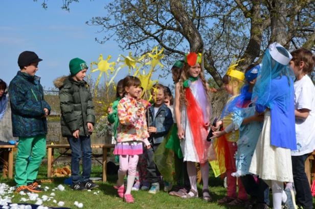 Eine Gruppe Kinder in Kostümen bei einer Aufführung im Freien.