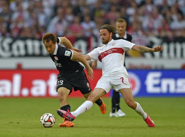 Zwei Fußballspieler kämpfen um den Ball auf dem Spielfeld.