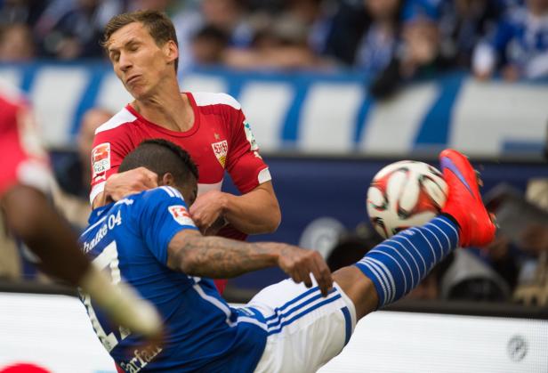 Ein Fußballspieler tritt im Zweikampf gegen einen anderen Spieler nach dem Ball.
