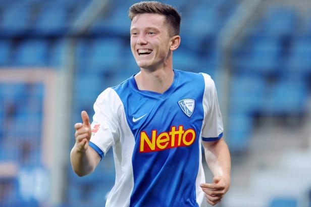 Ein lächelnder Fußballspieler des VfL Bochum in blau-weißem Trikot.