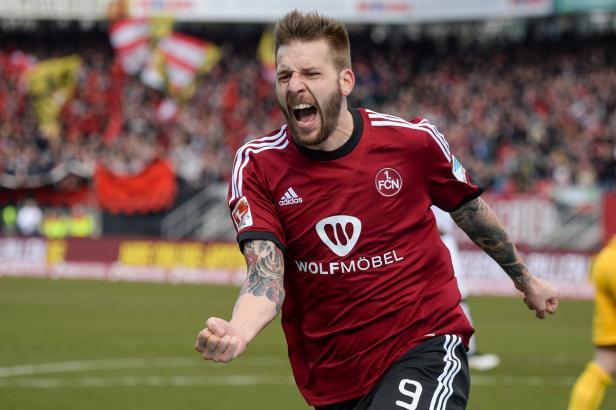 Ein jubelnder Fußballspieler des 1. FC Nürnberg auf dem Spielfeld.