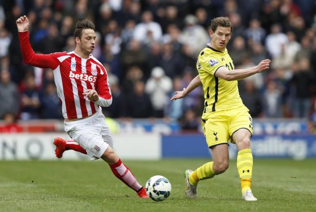 Zwei Fußballspieler kämpfen um den Ball auf dem Spielfeld.