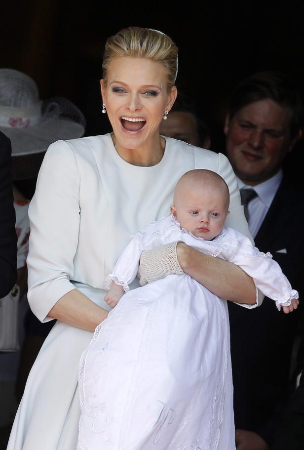 Fürstin Charlène von Monaco hält ein Baby im Arm.