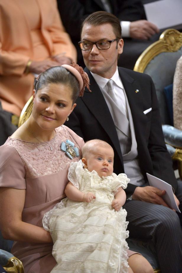 Kronprinzessin Victoria mit Ehemann Prinz Daniel und einem Baby im Arm.