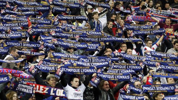 Eine große Menschenmenge schwenkt Schals des Fußballvereins Olympique Lyon.