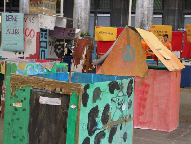 Eine bunte Stadt aus bemalten Pappkartons, die von Kindern gestaltet wurde.