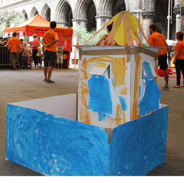 Kinder haben ein bunt bemaltes Pappboot gebaut.