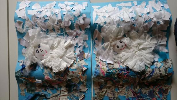 Zwei Kinderzeichnungen zeigen Engel vor blauem Himmel und einer Collage aus Papier und Garn.