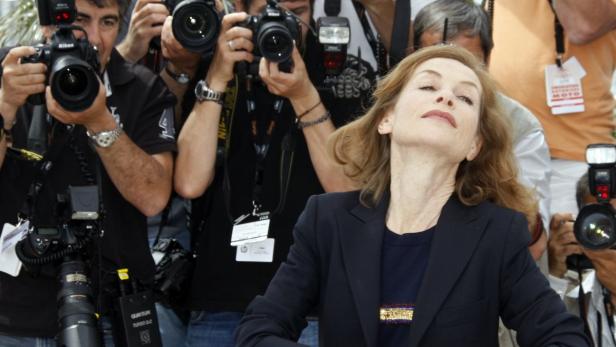 Isabelle Huppert posiert für eine Gruppe von Fotografen.