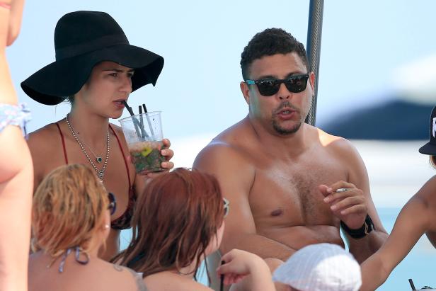Ronaldo sitzt mit einer Gruppe von Menschen auf einem Boot und raucht eine Zigarette.