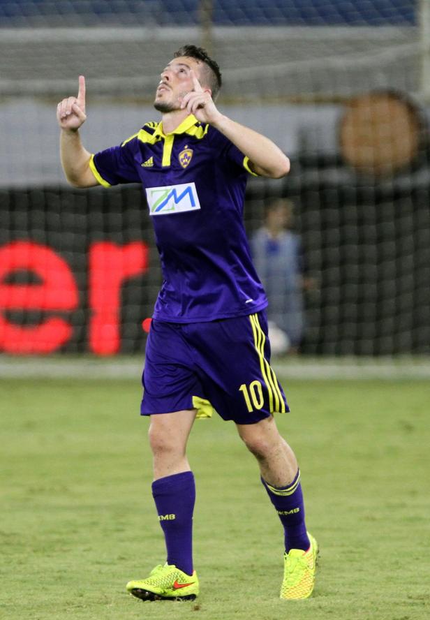 Ein Fußballspieler in lila Uniform jubelt mit erhobenem Zeigefinger.