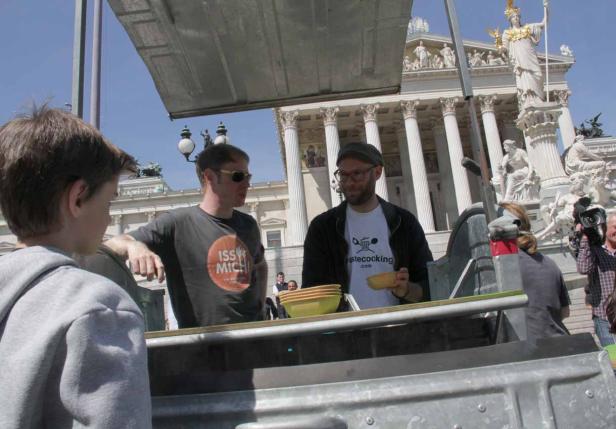 Zwei Männer stehen an einem Stand vor dem österreichischen Parlament in Wien.