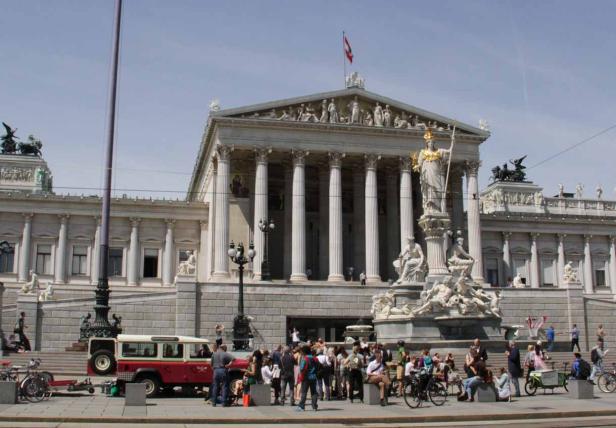 Das österreichische Parlament in Wien mit Menschen davor.