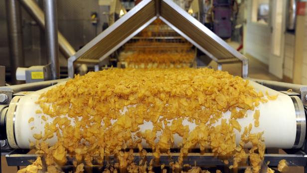 Cornflakes werden auf einem Förderband in einer Fabrik transportiert.