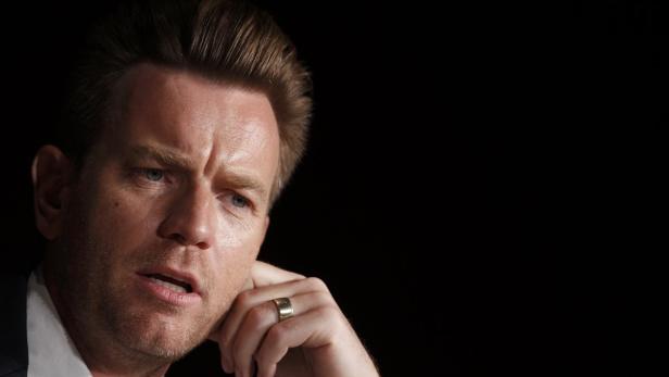 Ewan McGregor bei einer Veranstaltung, den Kopf auf seine Hand gestützt.