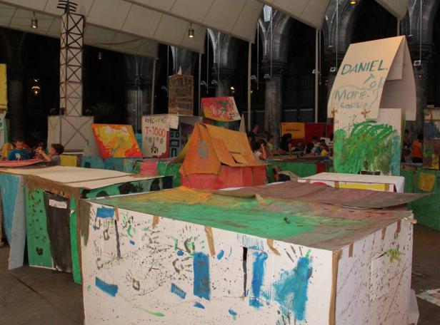 Kinder haben Hütten aus Kartons gebaut und bemalt.